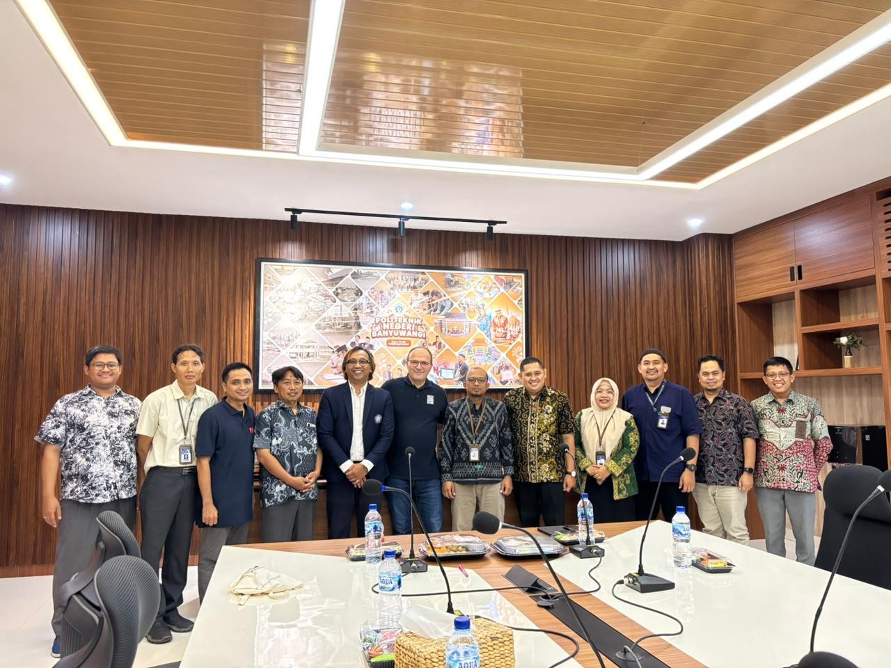 12 Personen in einer Reihe in einem Besprechungszimmer