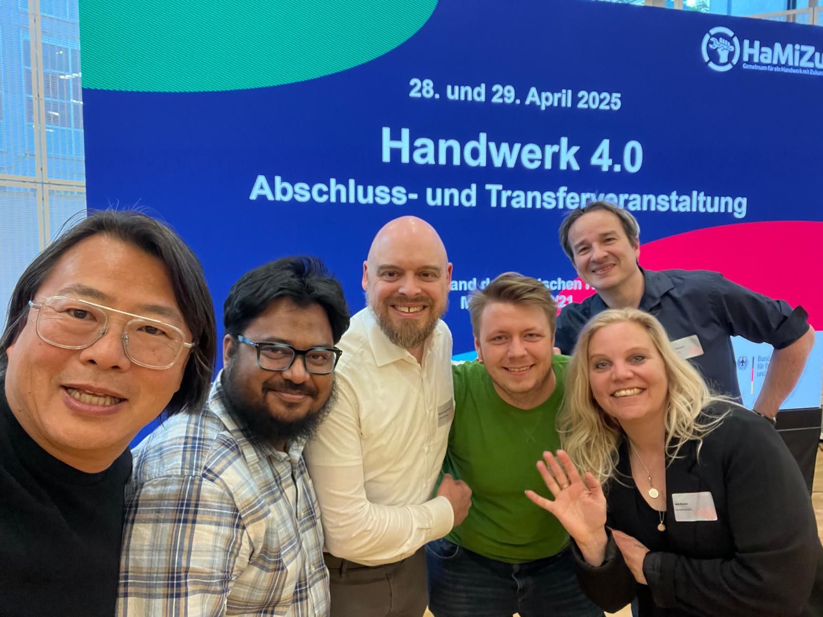 Gruppenselfie vor einem Banner der Handwerk 4.0