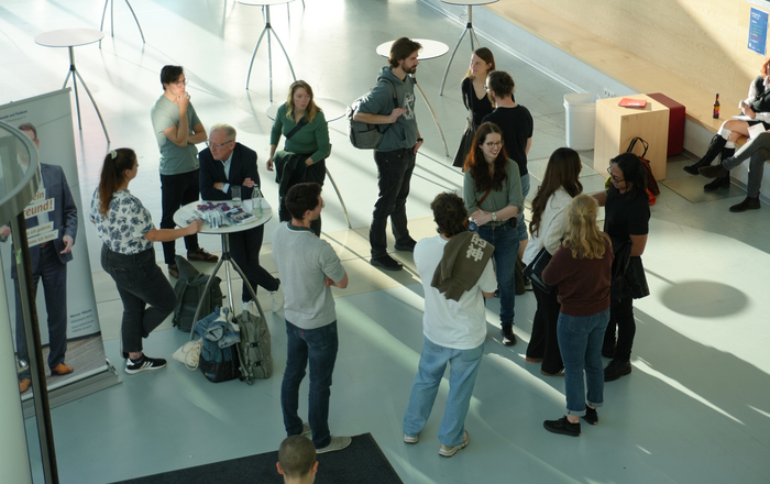 Menschen stehen im Foyer von Gebäude D zusammen