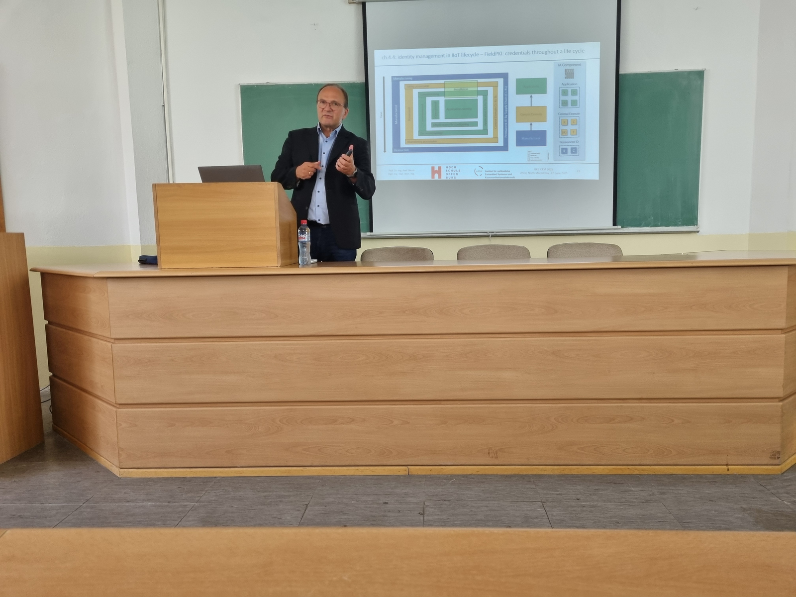 1 Person am Rednerpult vor einer Leinwand