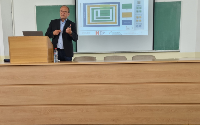 Ein Mann am Rednerpult vor einer Leinwand