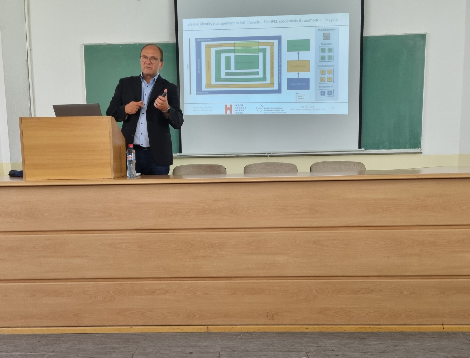 Ein Mann am Rednerpult vor einer Leinwand