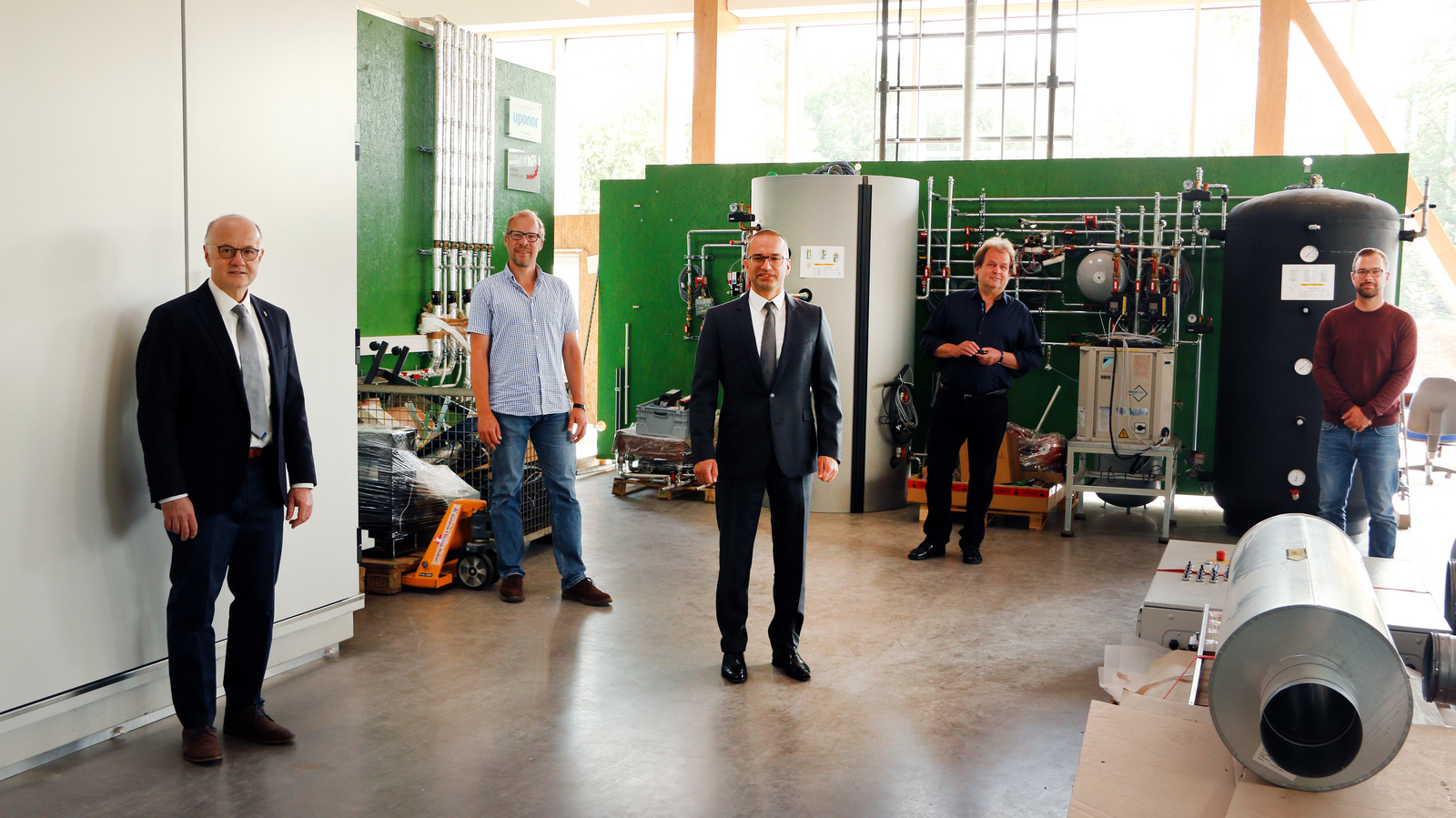Rektor Prof. Dr. Winfried Lieber, Prof. Dr. Jens Pfafferott, Kanzler Dr. Bülent Tarkan, Norbert Sigmund-Hafner vom Amt Freiburg Vermögen und Bau Baden-Württemberg sowie der technische Betriebsleiter Florian Bach (von links) im Technikum im RIZ Energie.