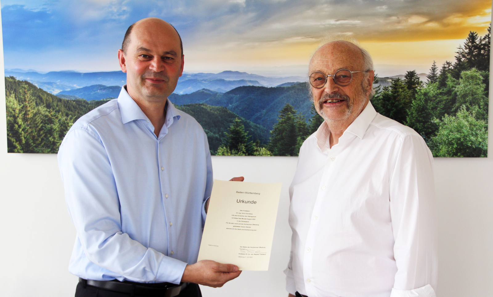 Rektor Prof. Dr. Stephan Trahasch (links) und Prof. Dr. Ulrich Hochberg (rechts) vor einem Schwarzwaldfoto