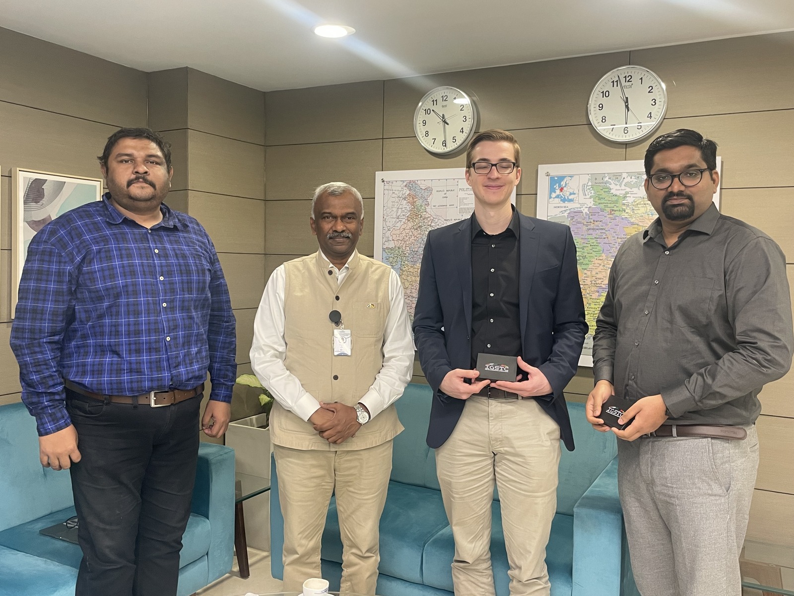 vier Männer stehen nebeneinander in einem Büro