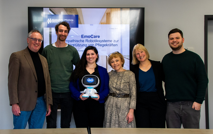 Gruppenbild vor einem Bildschirm