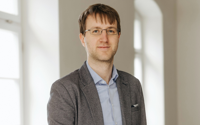 Ein Mann steht in einem Raum zwischen zwei Fenstern