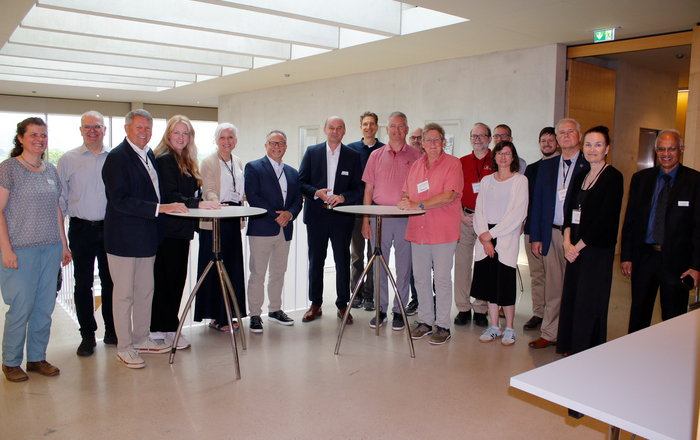 Gruppenfoto der an Stehtischen stehenden Gäste und Hochschulvertreter*innen