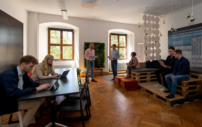 Prof. Dr. Andreas Klasen (3. von links) in einem Raum mit Studierenden 