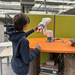 ein Junge interagiert mit einem Roboterarm