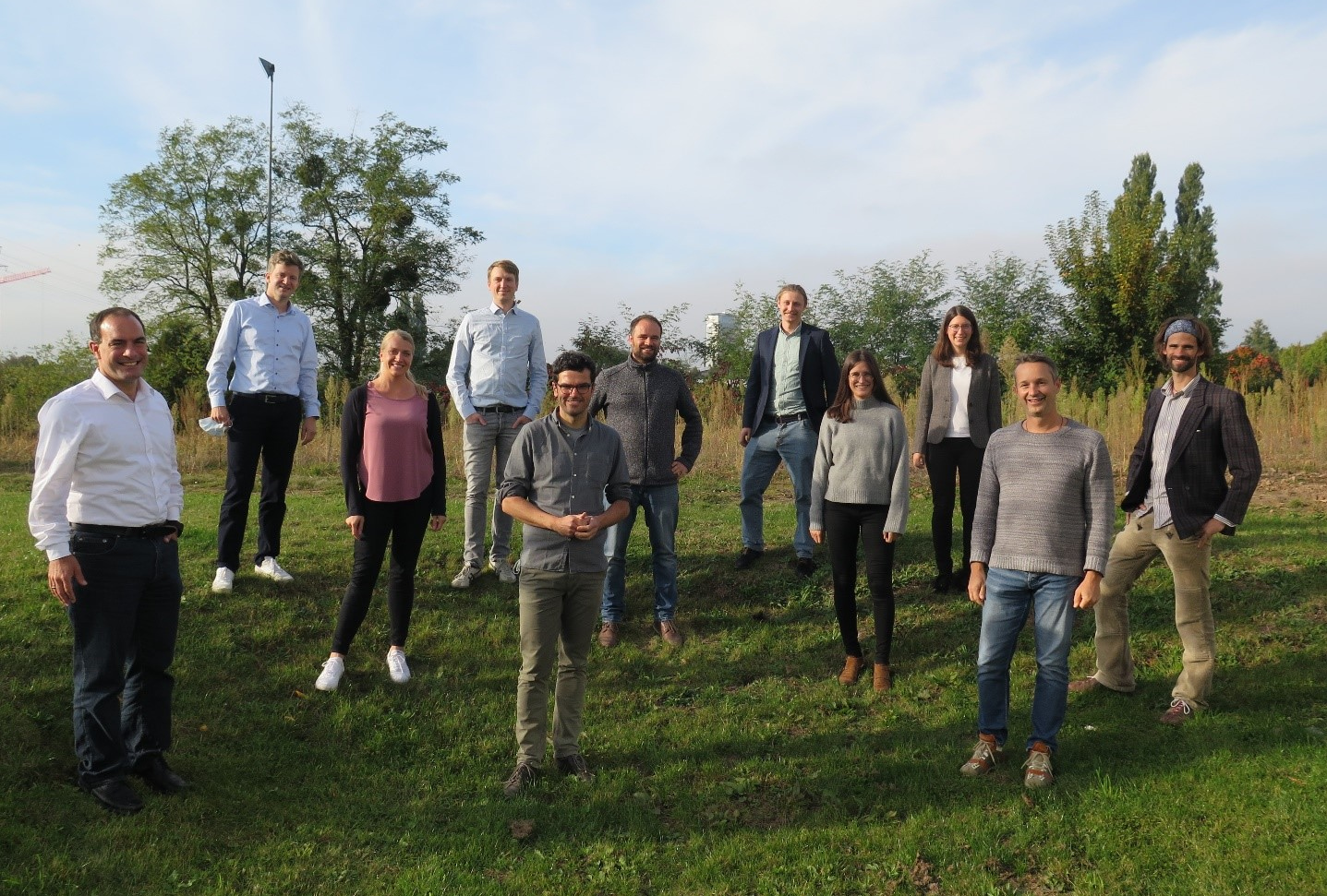 Elf Mitglieder des Projektkonsortiums stehen auf eine Wiese.
