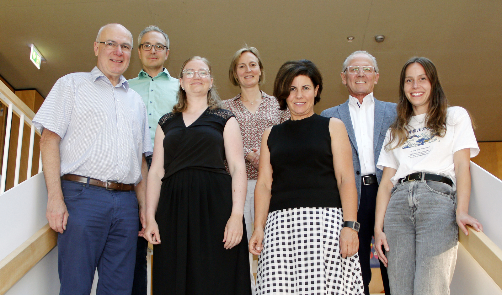 Gruppenfoto des wiedergewählten Vorstands und der Beirätinnen und -räte auf einer Treppe