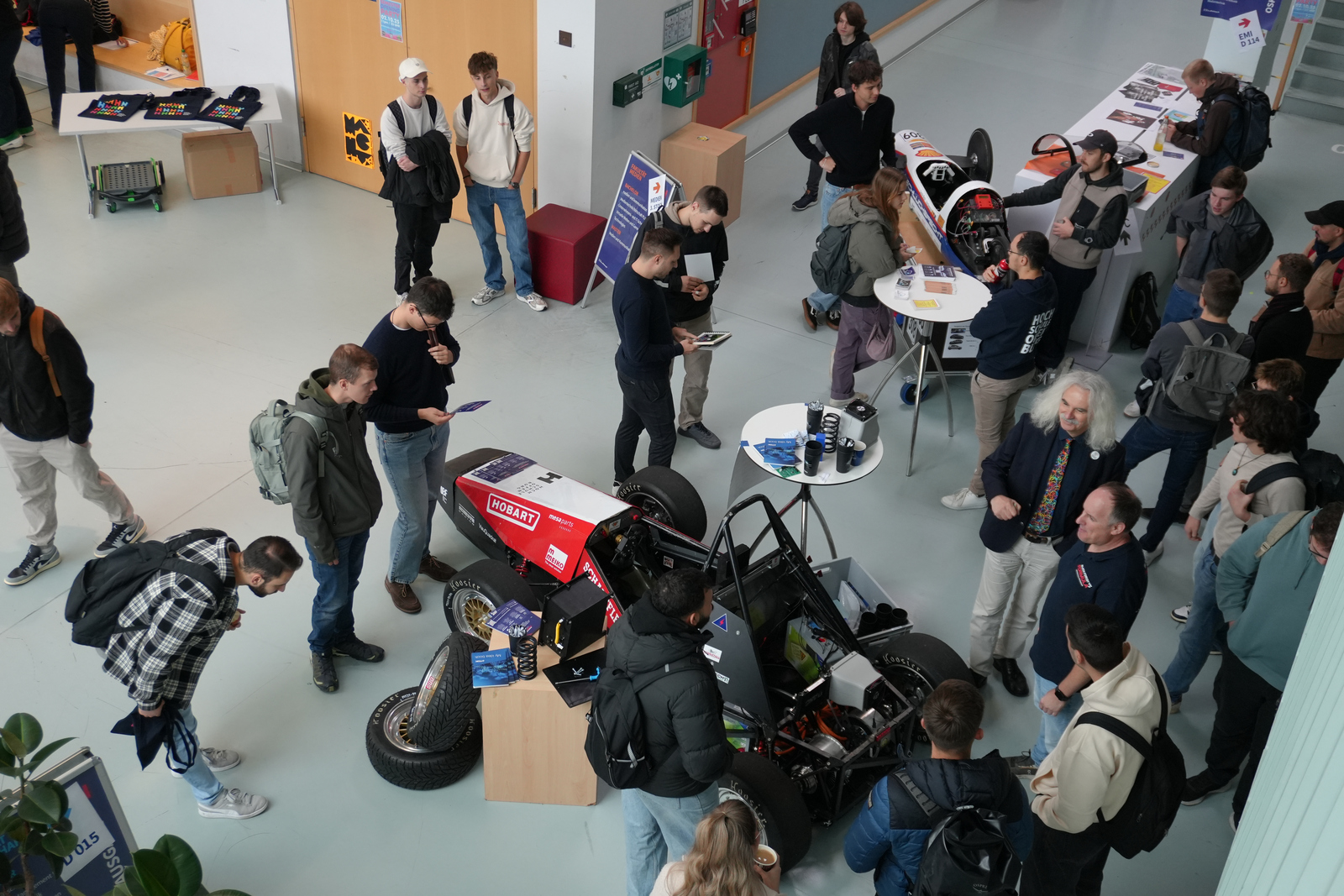 Blick von oben auf die von menschen umringten Autos des Team Schluckspecht und des Black Forest Formula Teams