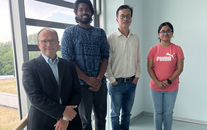 4 Personen nebeneinander, zum Teil auf der Treppe