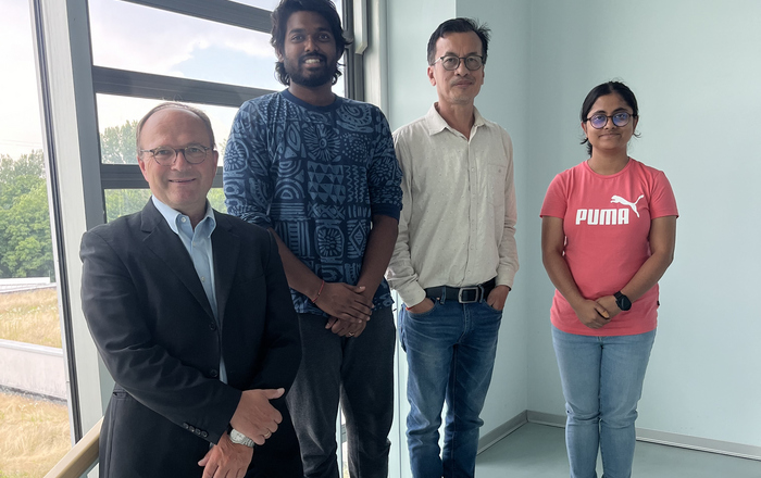 4 Personen nebeneinander, zum Teil auf der Treppe