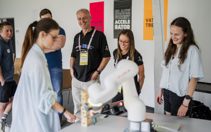  People watch a robotic arm