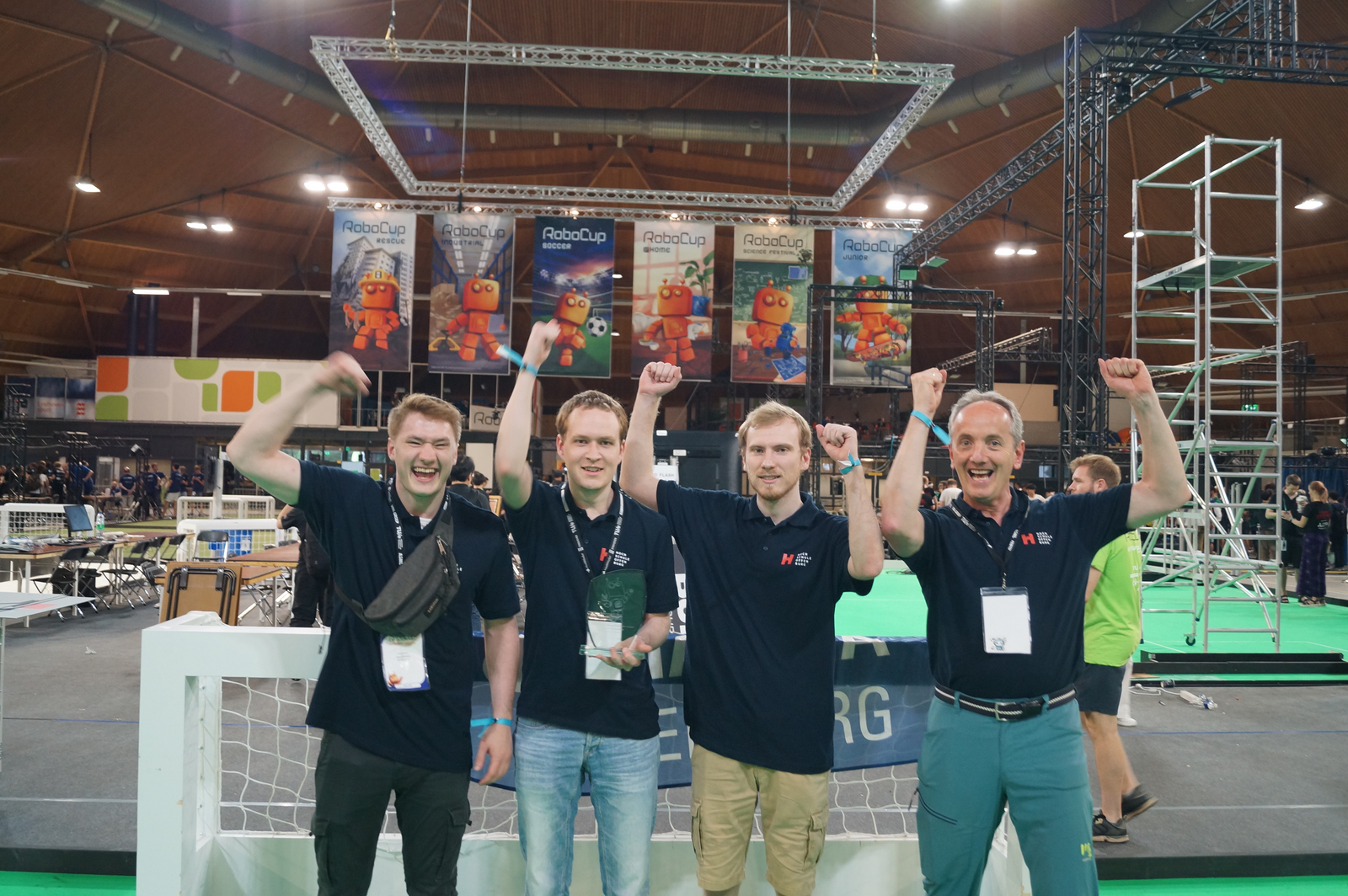 Drei Studierende und Prof. Dorer mit dem Pokal in Jubelpose