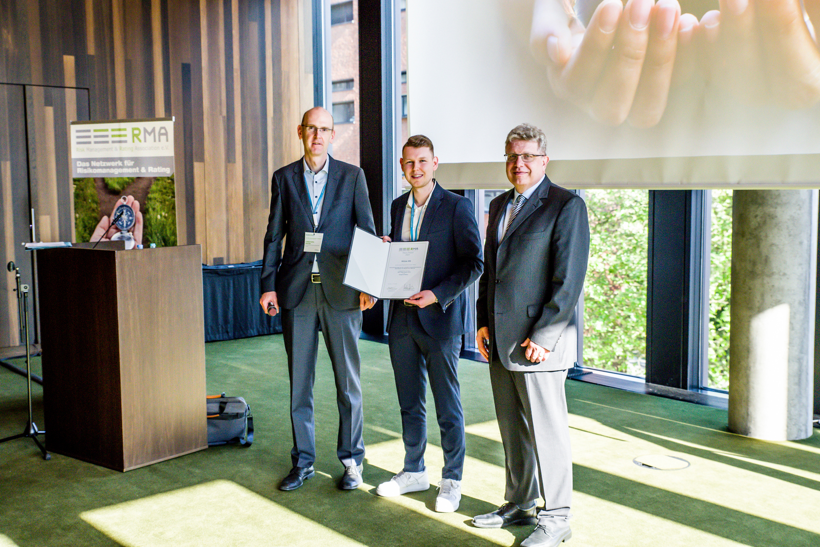 Auf dem Bild sind Preisträger Niclas Ott, Prof. Dr. Christoph Mayer (Hochschule Dresden) und Prof. Ulrich Bantleon (Hochschule Offenburg) zu sehen.
