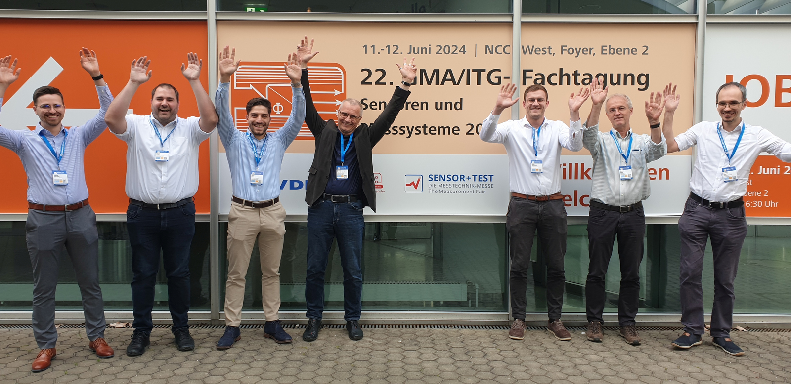 Group photo of the wlri-team at the symposium with arms raised in jubilation