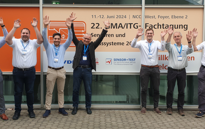Group photo of the wlri-team at the symposium with arms raised in jubilation
