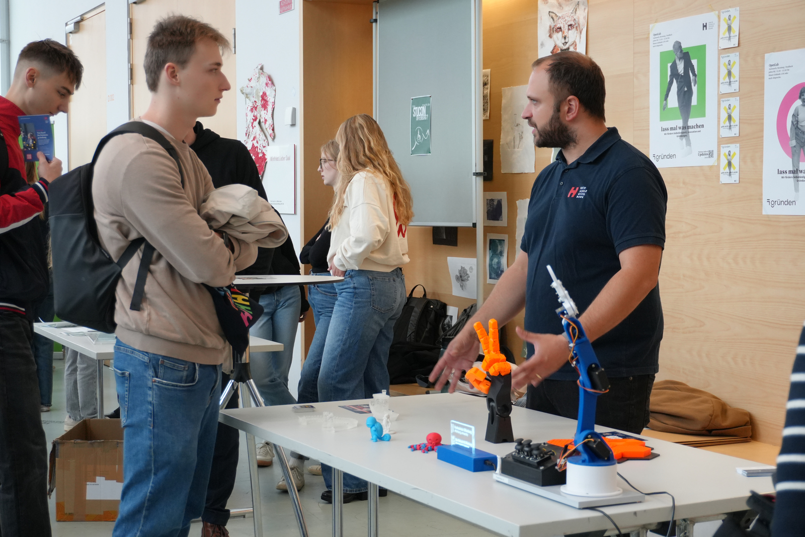 zwei Männer stehen an einem Tisch mit 3D-gedruckten Objekten
