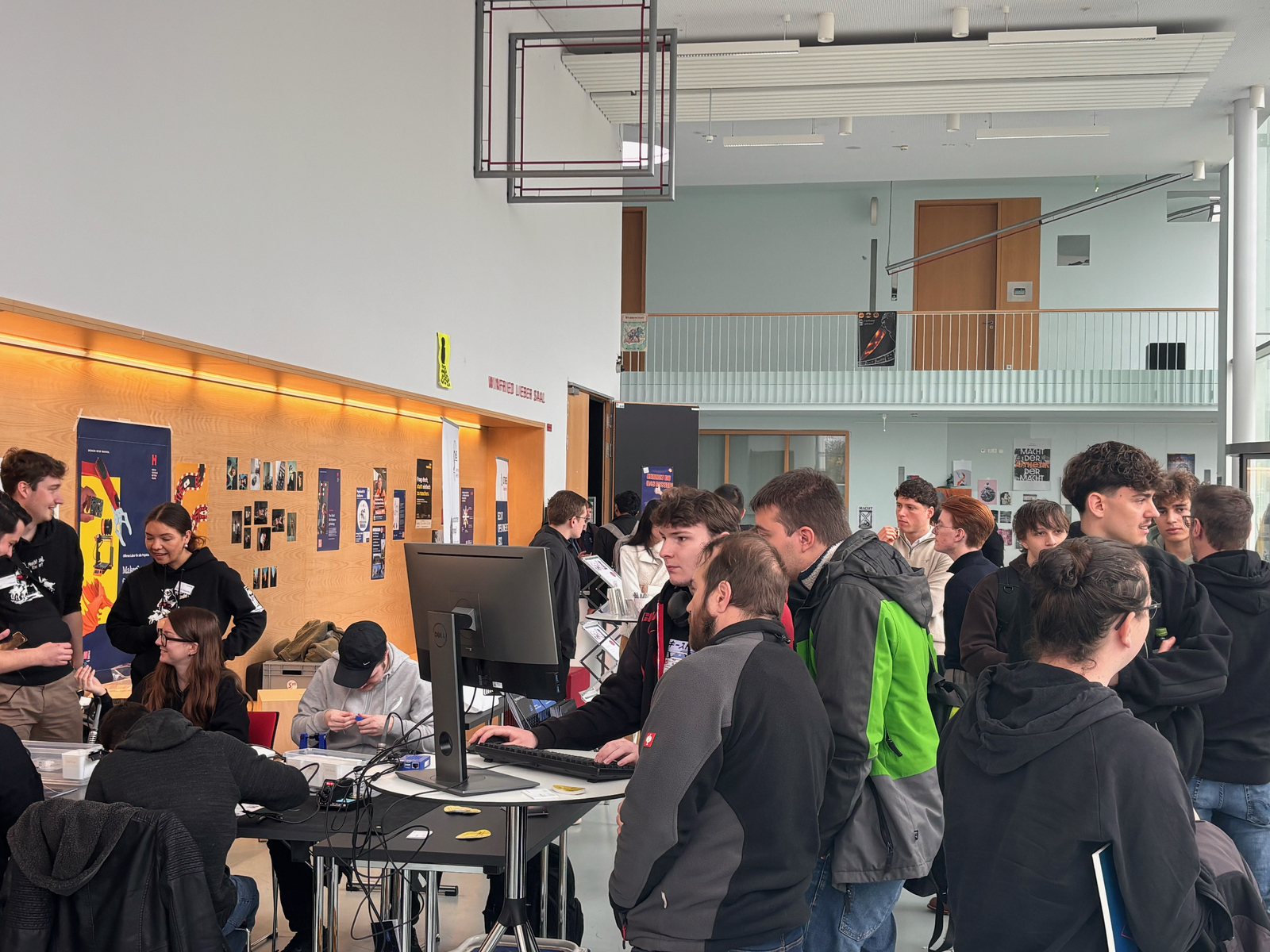Jungen Menschen in einem Foyer an verschiedenen Ständen