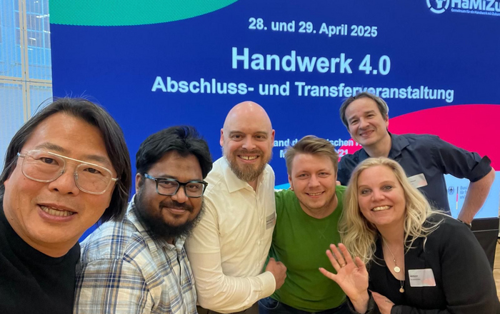 Gruppenselfie vor einem Banner der Handwerk 4.0