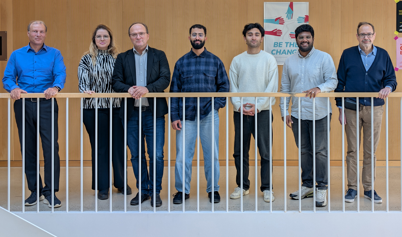 7 Personen in einer Reihe nebeneinander stehend