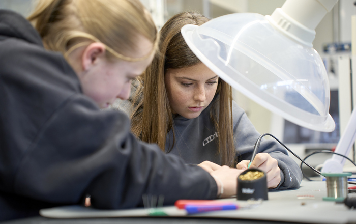 Zwei Mädchen löten etwas zusammen