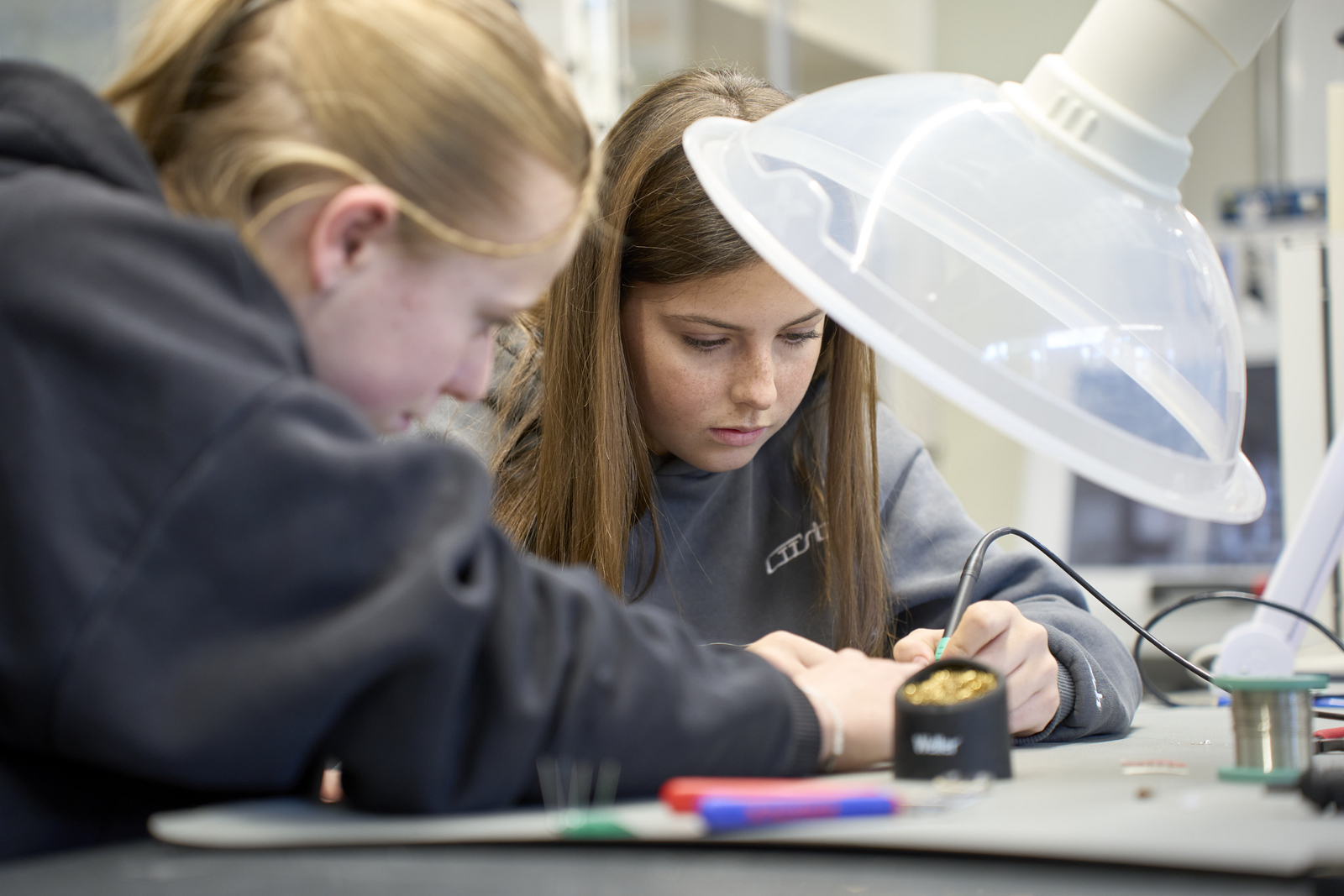 Zwei Mädchen löten etwas zusammen