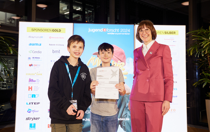 Zwei der drei Sonderpreisträger in der Sparte Schüler*innen experimentieren bei der Preisverleihung