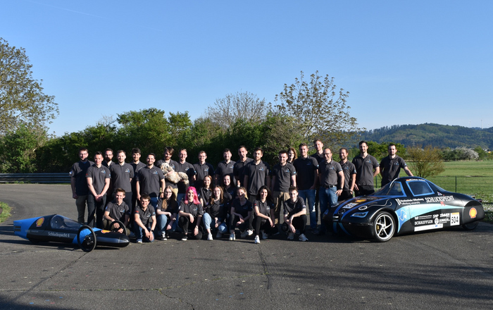 Gruppenbild des Teams mit den beiden Schluckspechten auf der Teststrecke