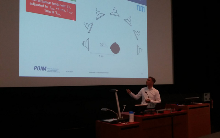 Julian Angermeier vor der leinwand mit seiner Power-Point-Präsentation. 