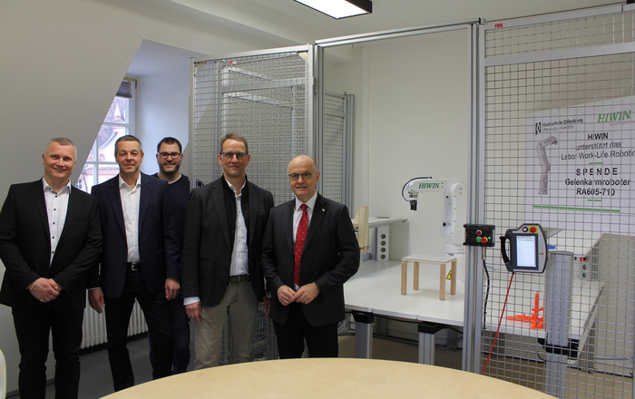 von links) Prof. Dr. Thomas Wendt, Joachim Roos, Leiter der Hiwin-Entwicklungsabteilung, Doktorand Nikolai Hangst, Hiwin-Geschäftsführer Werner Mäurer und Rektor Prof. Dr. Winfried Lieber vor dem neuen Gelenkarmroboter.