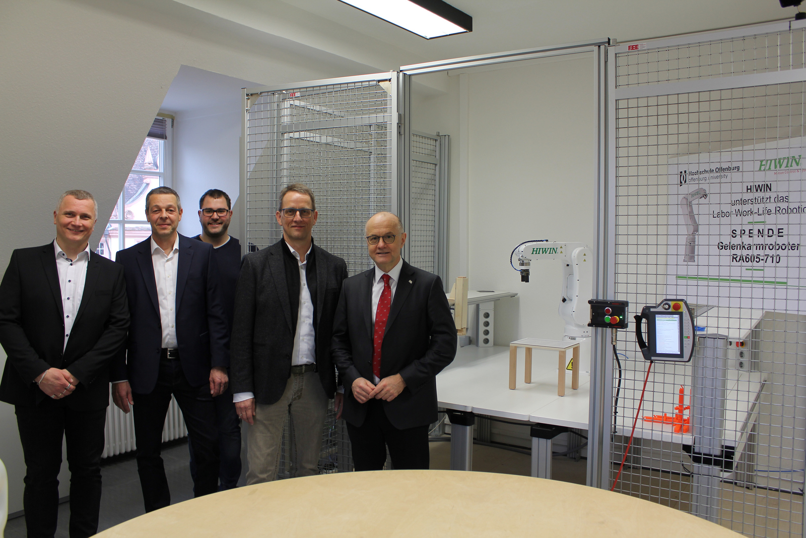 von links) Prof. Dr. Thomas Wendt, Joachim Roos, Leiter der Hiwin-Entwicklungsabteilung, Doktorand Nikolai Hangst, Hiwin-Geschäftsführer Werner Mäurer und Rektor Prof. Dr. Winfried Lieber vor dem neuen Gelenkarmroboter.