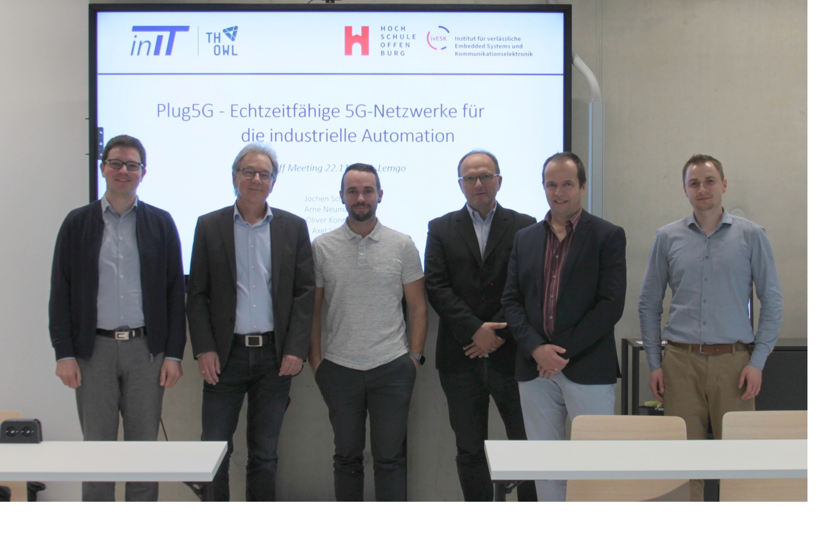 5 Personen in Reihe vor einem Whiteboard mit dem Projektnamen.