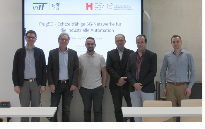 5 Personen in Reihe vor einem Whiteboard mit dem Projektnamen.