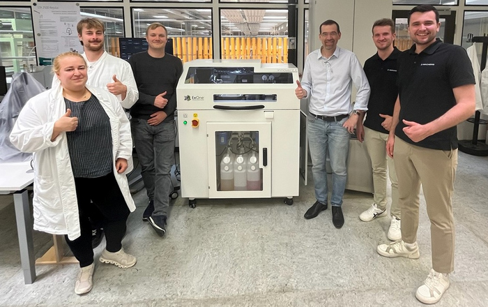 Menschen stehen in einem Labor umd das Gerät herum 