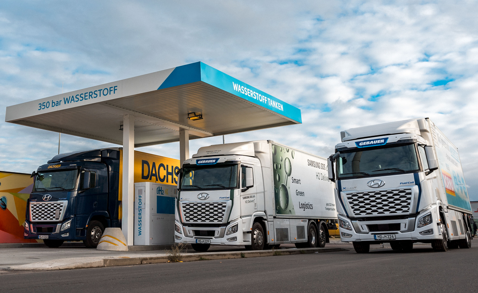 Visaulsierung von drei Lastwagen, die an einer Wasserstofftankstelle stehen