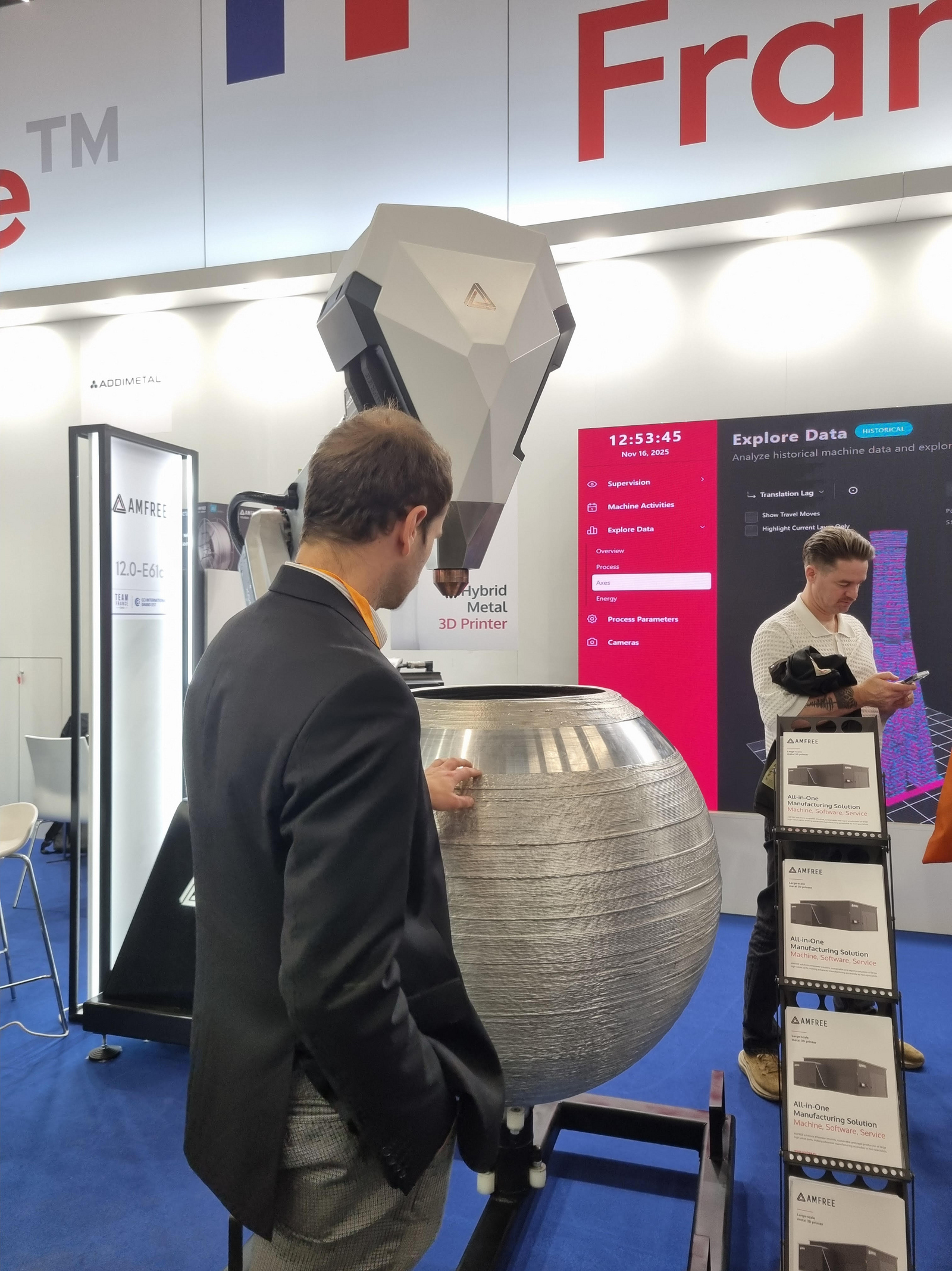 Daniel Kehret bestaunt eine große 3D gedruckte Vase aus Metall, die von einem robotergestützten, hybriden Metall 3D Drucker der Firma AMFree gefertigt wurde.