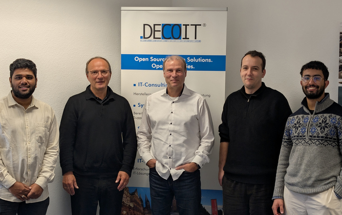 5 Personen nebeneinander vor einem DECOIT RollUp