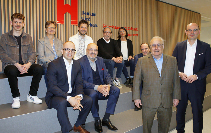 Gruppenfoto der Beteiligten auf der neuen spanischen Treppe in Holzlamellenoptik sitzend beziehungsweise davor stehend