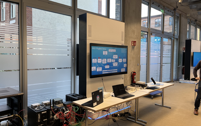 ein Elektronikaufbau an einem Tisch mit einem Bildschirm an der Wand