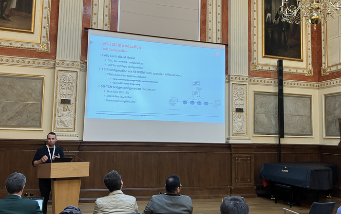 1 person am Rednerpult, Leinwand im Hintergrund