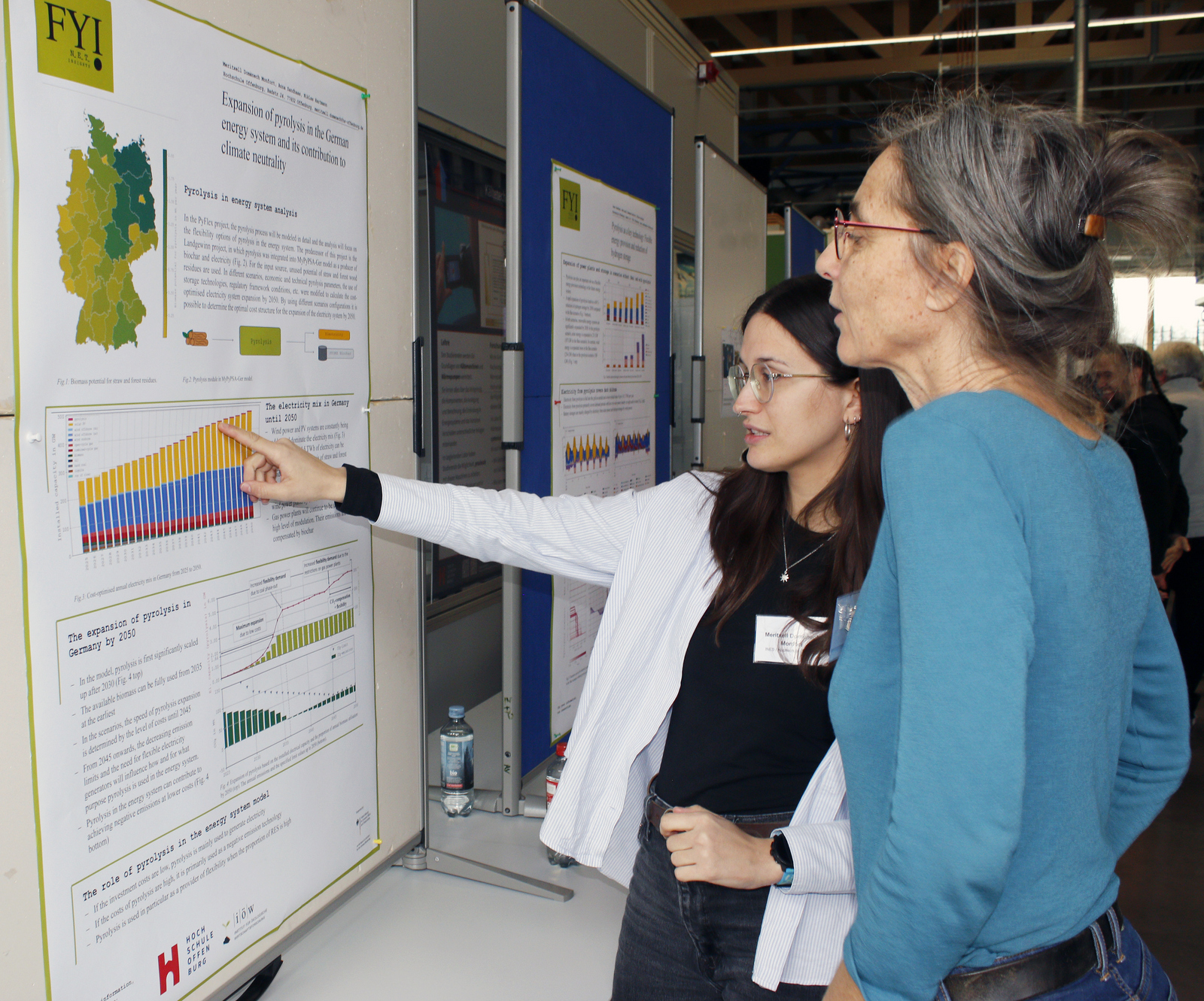 Zwei Frauen studieren ein Projektposter