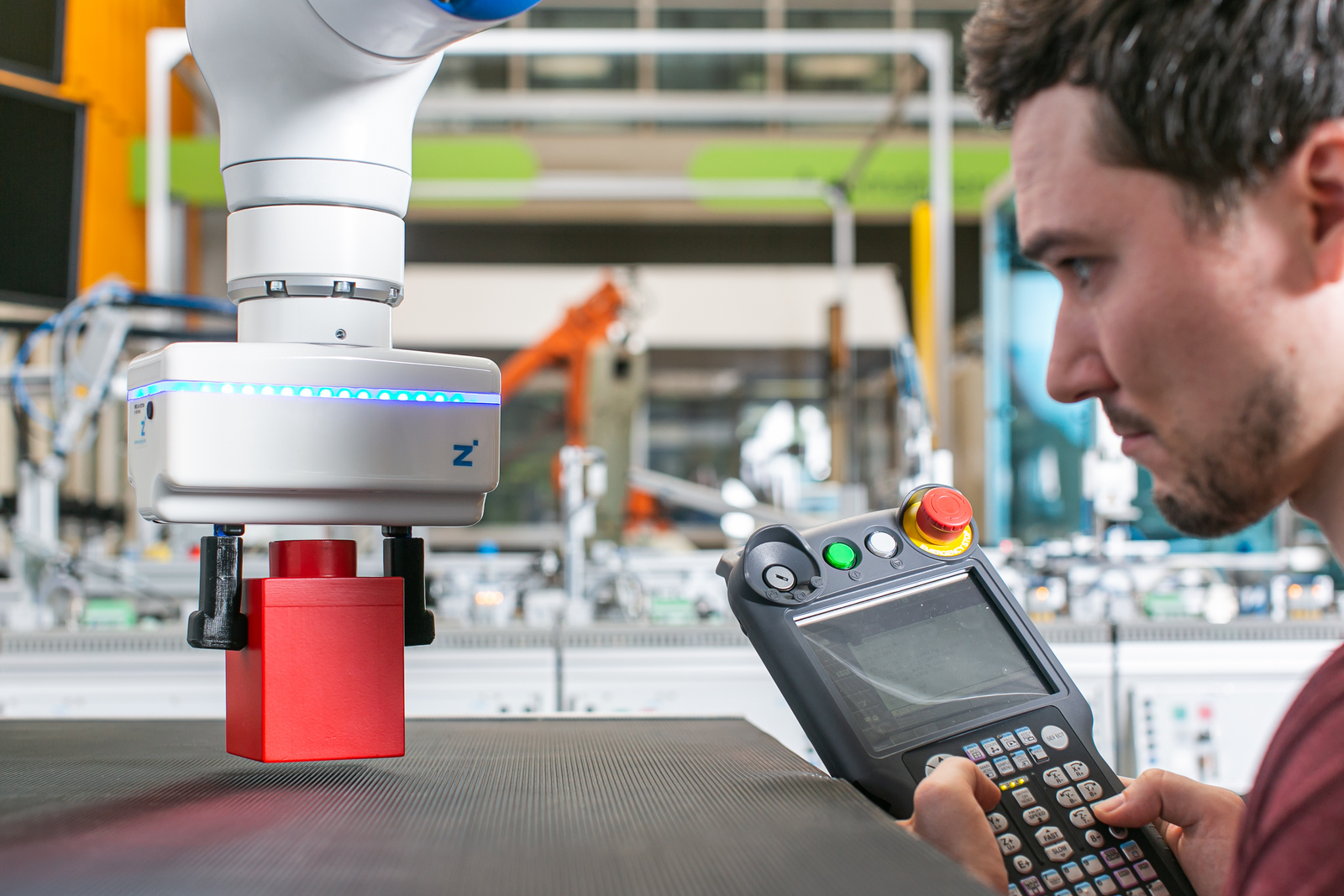 Student programmiert Roboterarm, der Klötzchen bewegt