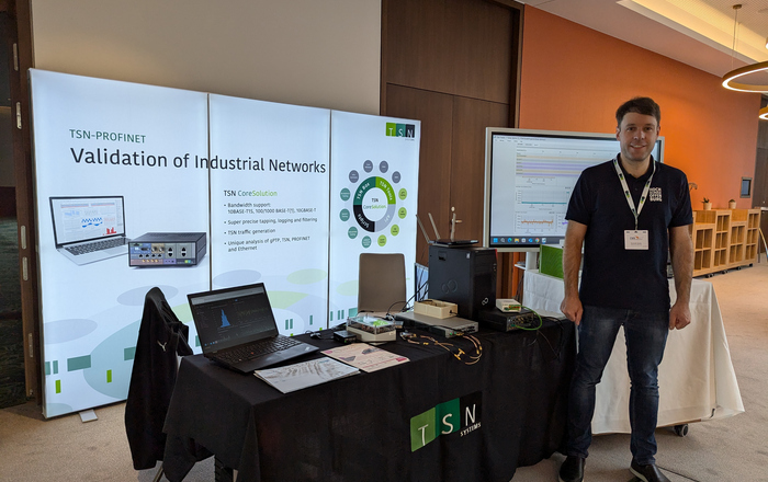 Dominik Welte infrot of the booth of TSN Systems