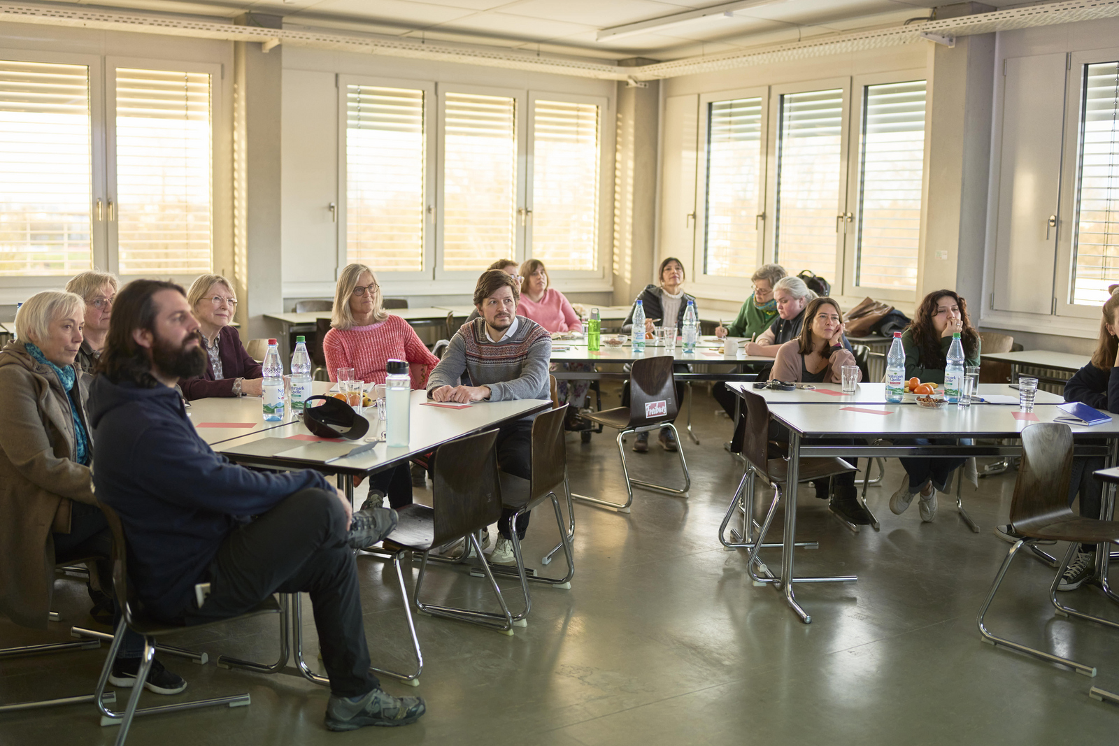 Publikum aus Verwaltungspersonal und Lehrkräften an der Hochschule, das einer Präsentation über sprachliche Inklusivität in Bildungseinrichtungen zuhört.