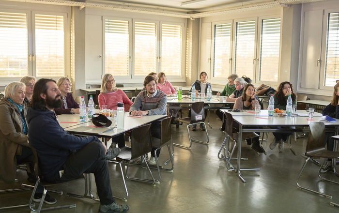 Publikum aus Verwaltungspersonal und Lehrkräften an der Hochschule, das einer Präsentation über sprachliche Inklusivität in Bildungseinrichtungen zuhört.