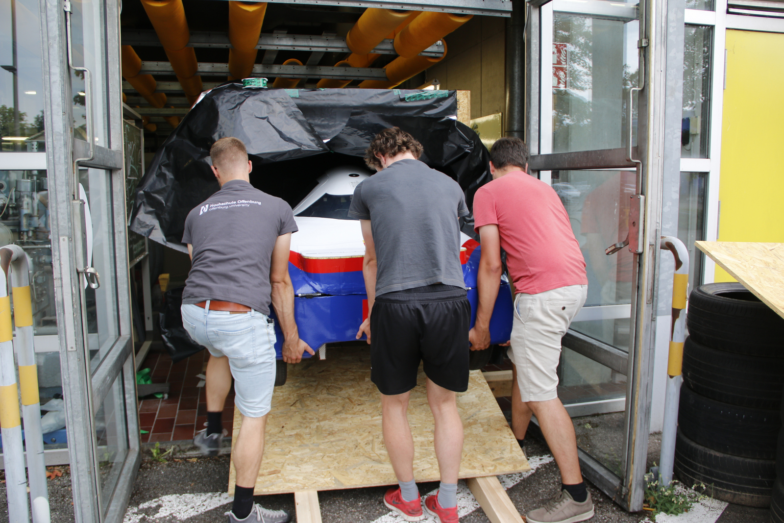 Studierende schieben Auto ganz in Kiste